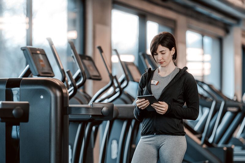 Fitnesstrainerin am Tablet